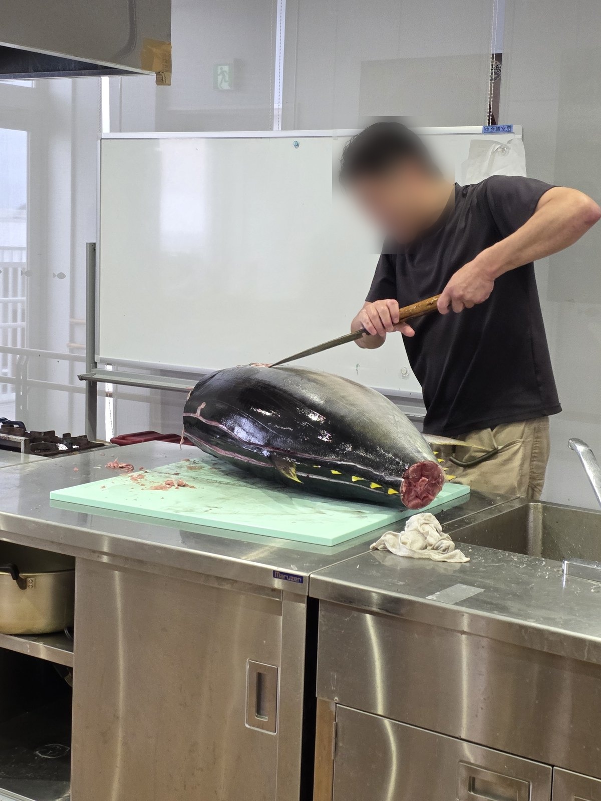 マグロを解体する人。同意がまだなので顔をぼかしている