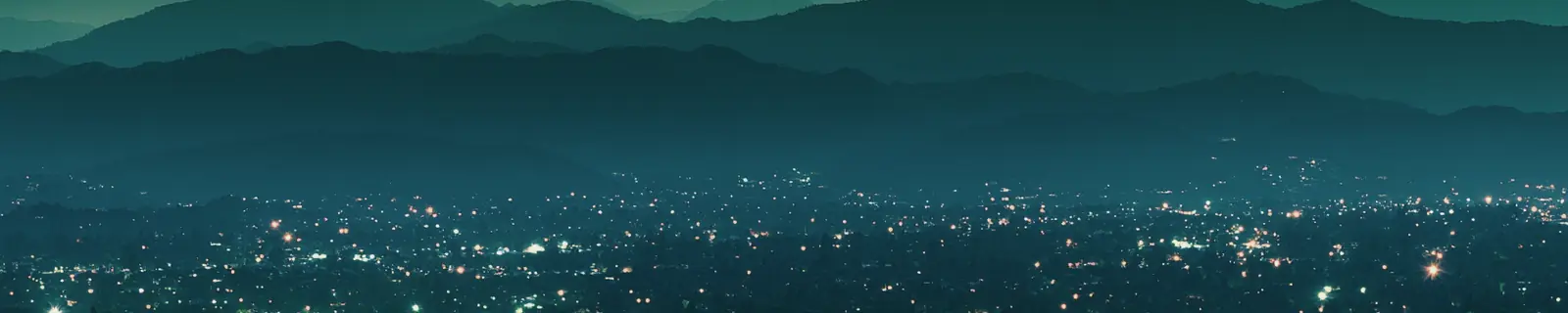 山に囲まれた盆地に街の灯りが広がる夜景。台北の都市感のイメージ図です。