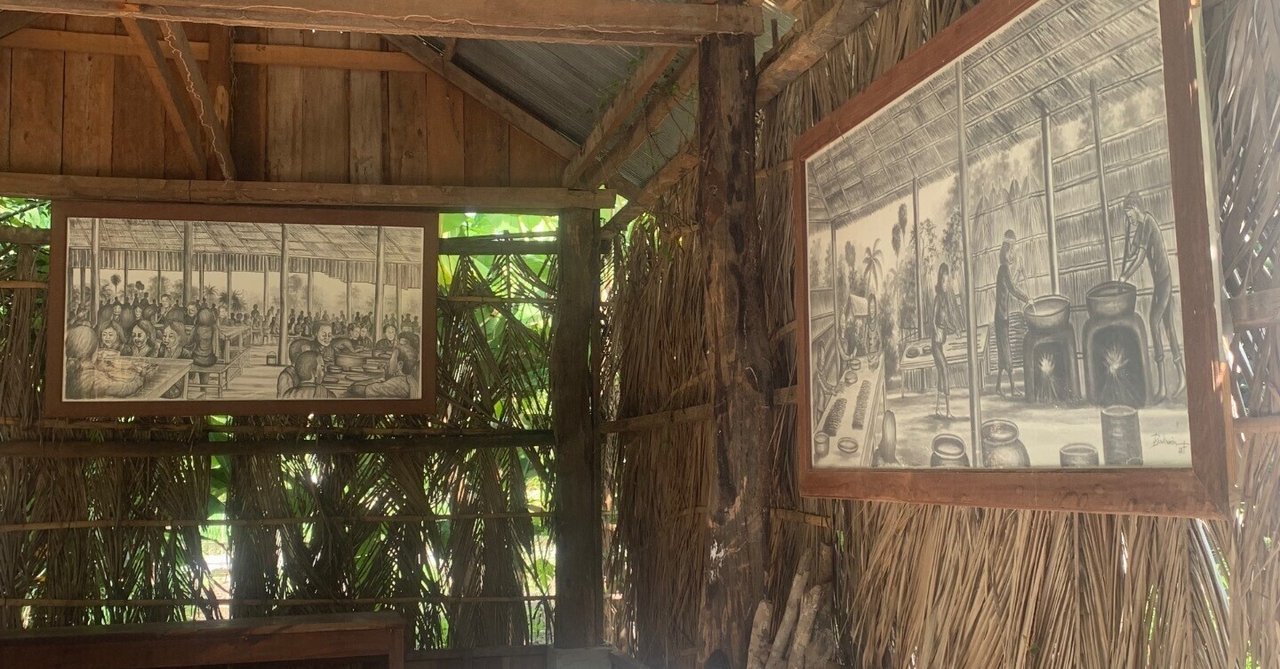 カンボジアの展示施設で、歴史を描いた絵が木造の壁に掛けられている