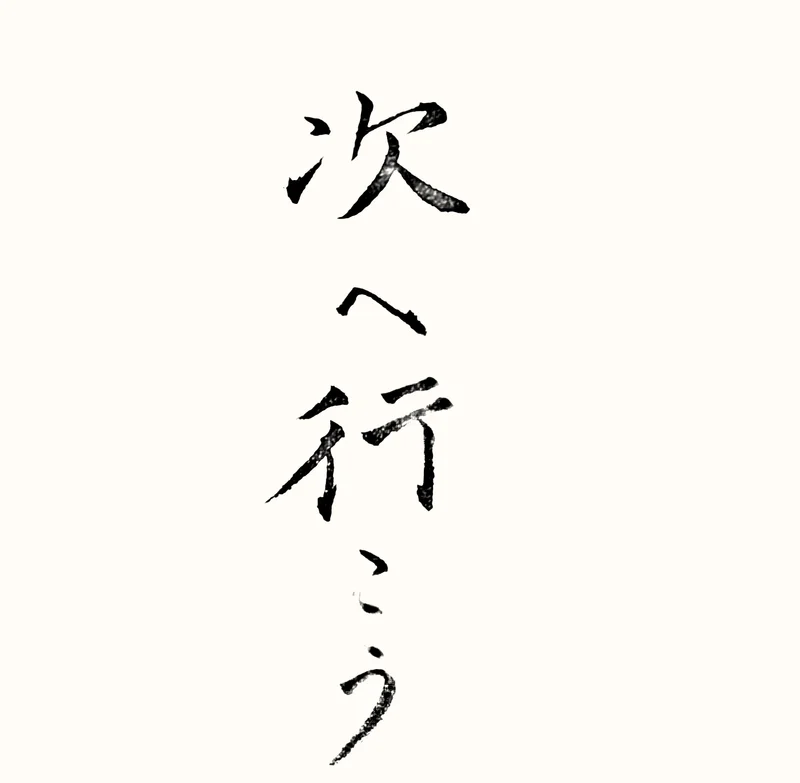 「次へ行こう」と書いた直筆の書