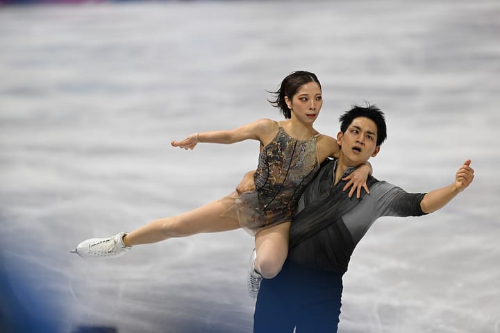 2026年ミラノ・コルティナ五輪ペアフリーで演技する三浦璃来と木原龍一。木原が三浦を支え、二人が同じ方向へ腕を伸ばしている