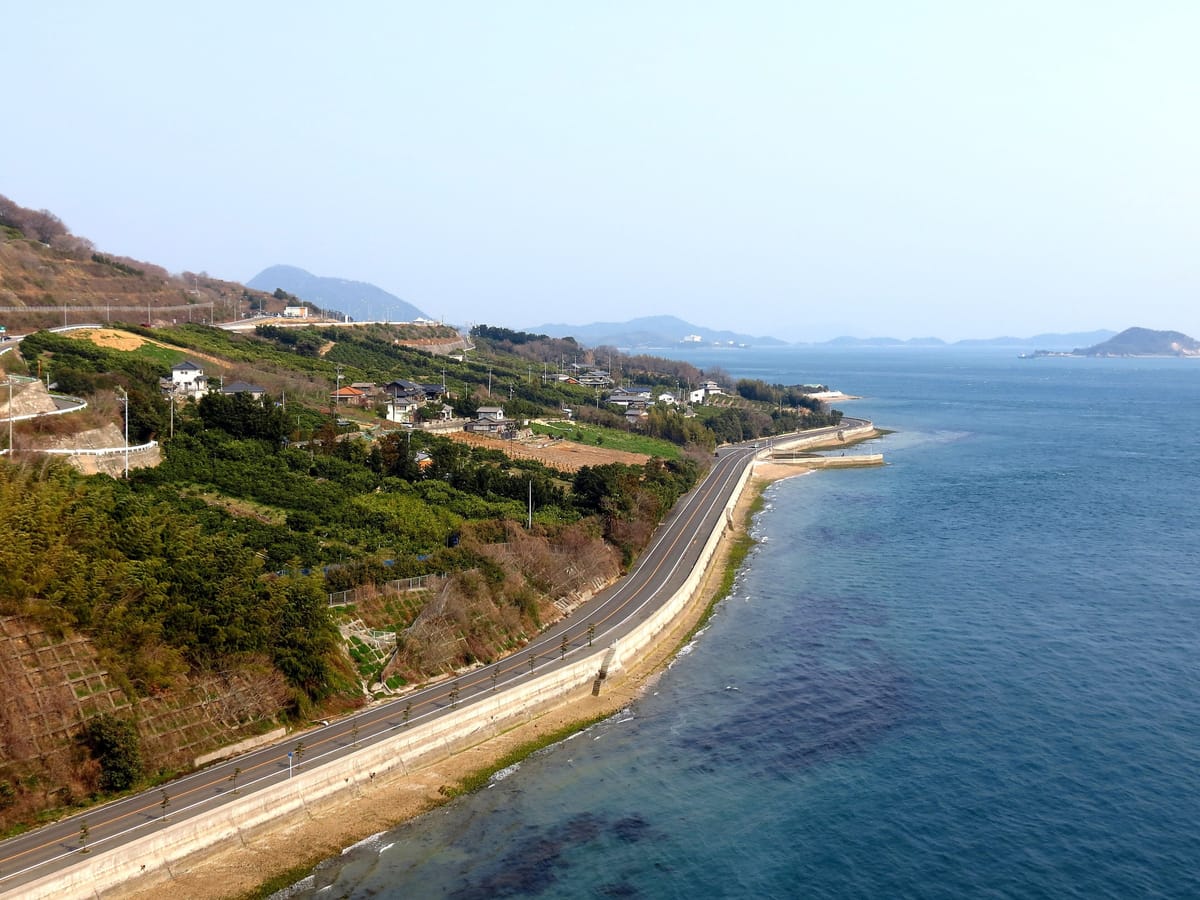 Ikuchijima seen from the Tatara Bridge: coastal road and citrus slopes