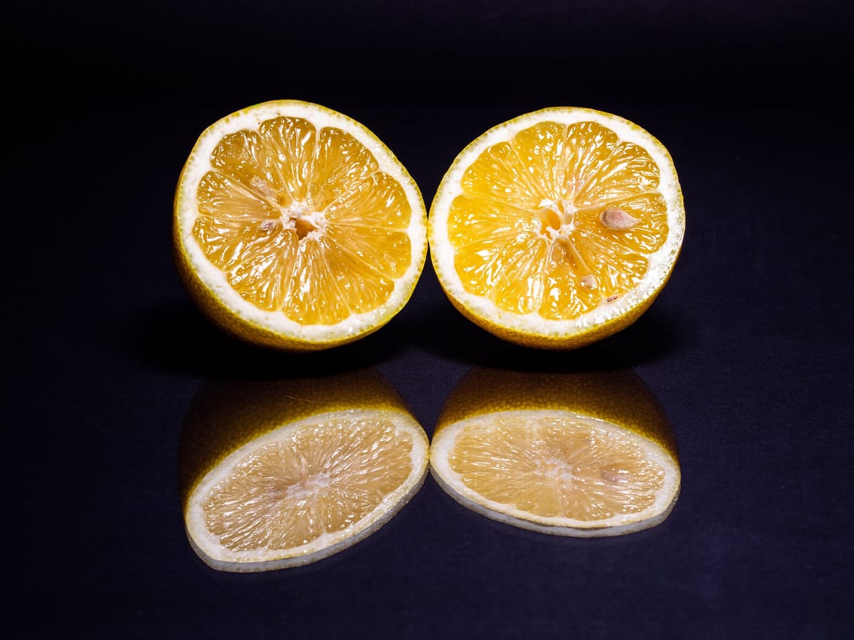 Lemon halves on a black mirror surface