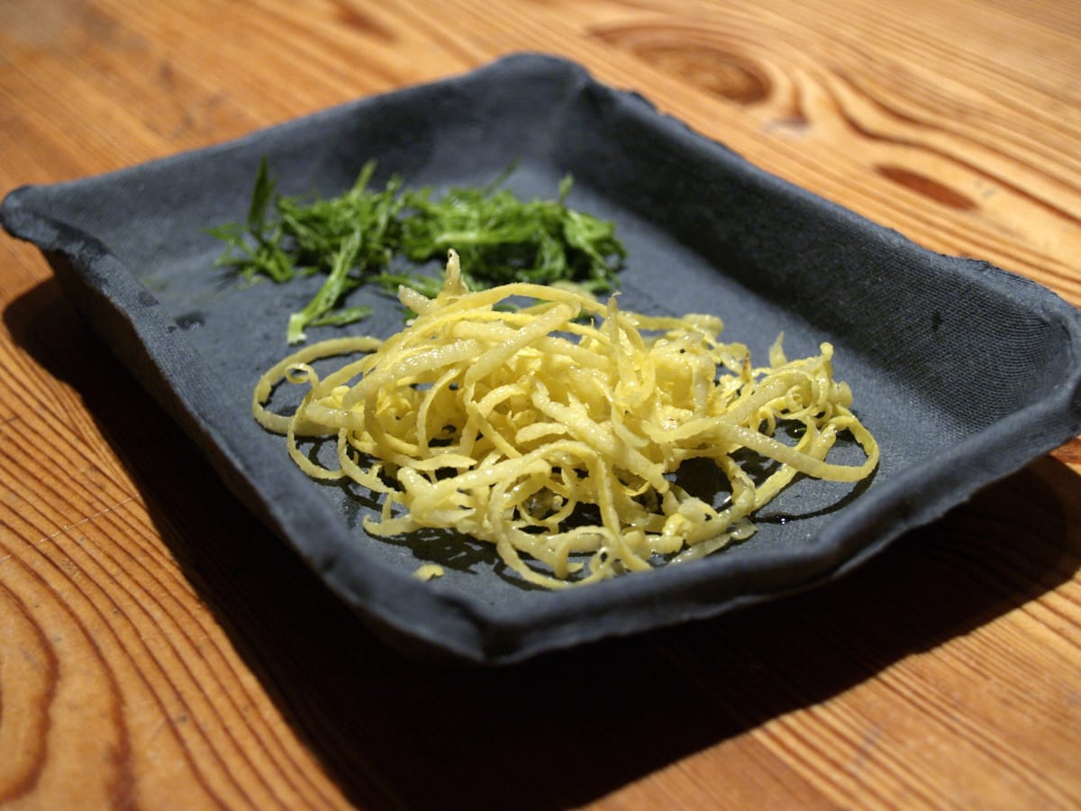 Fine strips of lemon zest with fennel shoots
